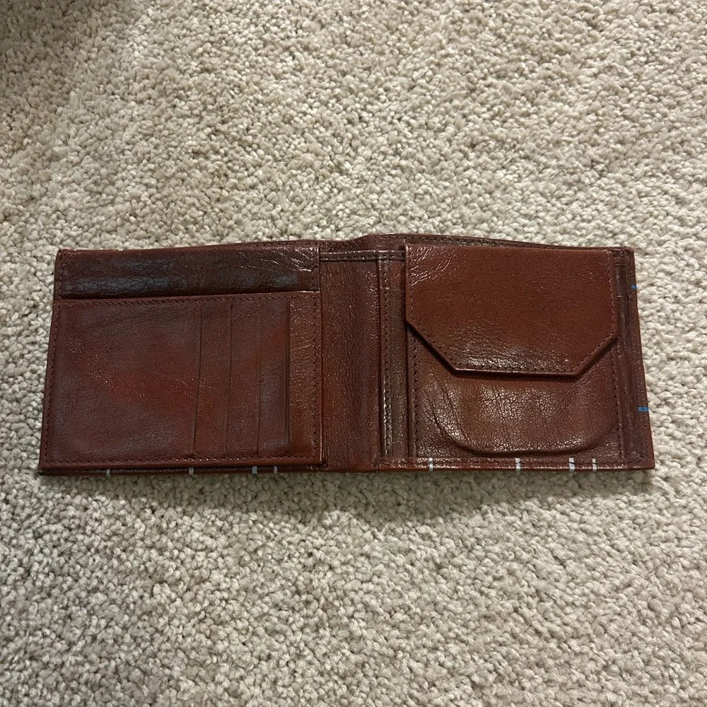 Hurly men's bifold leather wallet with a hands-up logo and nomad print inlay